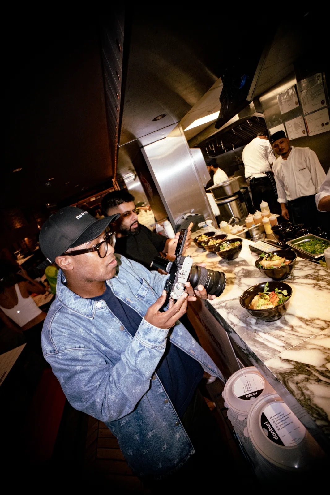 Jay Baptiste filming food at Wagamama